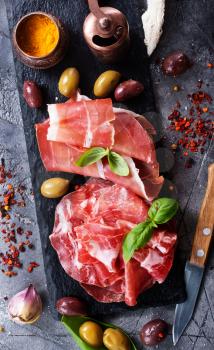 prosciutto with olives and spice on a table