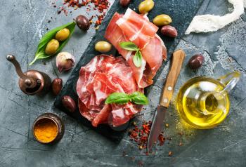 prosciutto with olives and spice on a table