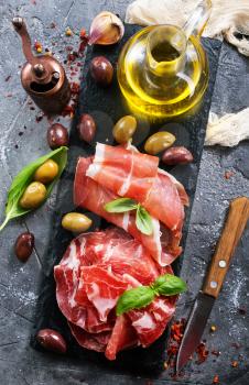 prosciutto with olives and spice on a table