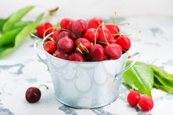 fresh cherry in metal bowl and on a table