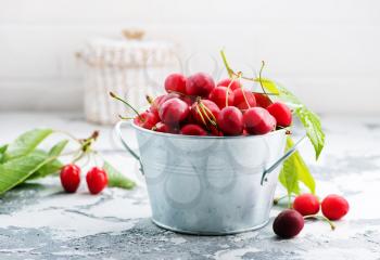 fresh cherry in metal bowl and on a table