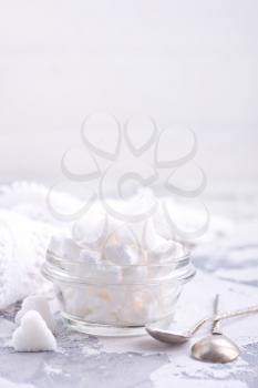 white sugar in glass bowl and on a table