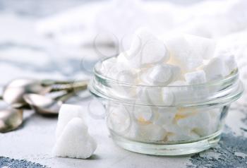 white sugar in glass bowl and on a table