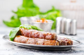 raw sausages with spice on the metal plate