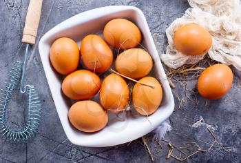 raw eggs in bowl and on a table