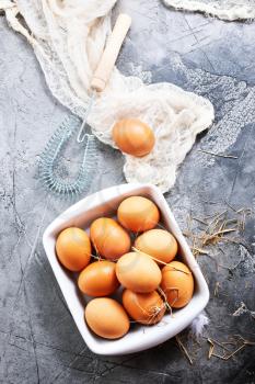 raw eggs in bowl and on a table