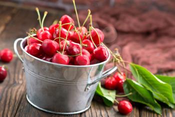 red cherry in bowl and on a table