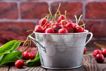 red cherry in bowl and on a table