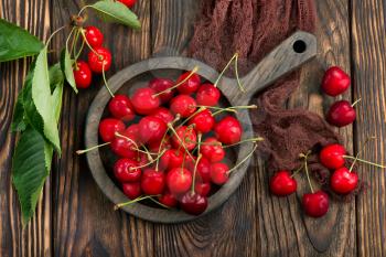 red cherry in bowl and on a table