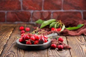 red cherry in bowl and on a table