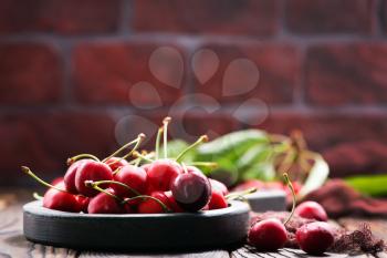 red cherry in bowl and on a table