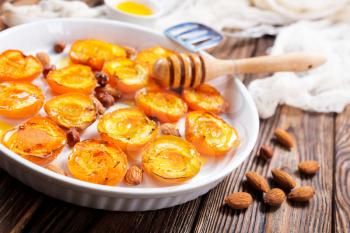 baked apricots with honey and nuts on a table