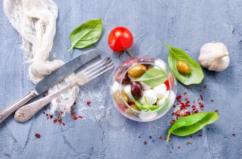 caprese salad in glass bowl and on a table