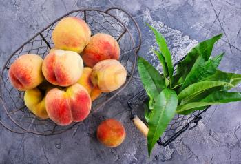 fresh peach in metal basket and on a table