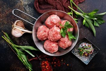 raw meatballs with salt and spice on a table