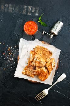 Pan fried fish with tomato sauce on a table