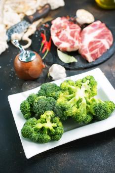 raw meat and fresh broccoli on a table