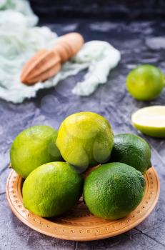 fresh limes on plate and on a table