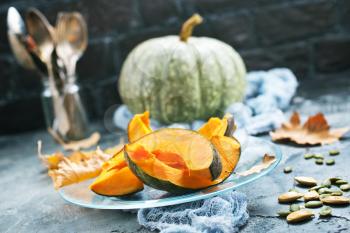 raw pumpkin on plate and on a table