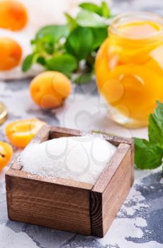sugar and apricots on a table, ingredients for cooking jam