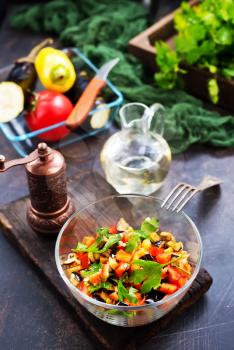 fried eggplant and red pepper, vegetables in glass bowl