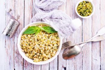 boiled bulgur with sauce Pesto in white bowl