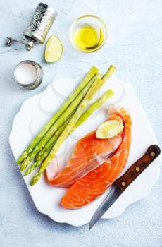 raw salmon and green asparagus on plate