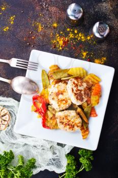 baked vegetables with cutlet on white plate