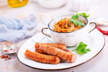 sausage with cabbage on the plate, fried sausages
