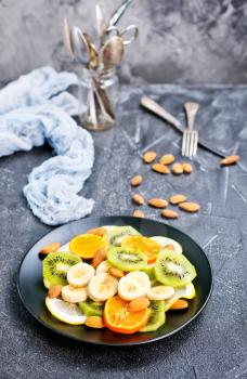 fruit salad with almond on black plate