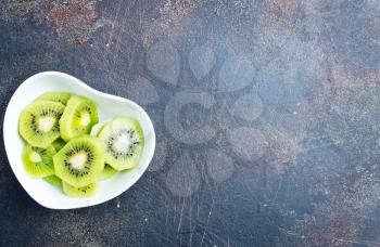 Still life image of sliced kiwi fruit on white plate
