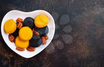 colorful macaroons with dry pecan in bowl