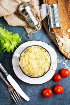 boiled noodles with grated cheese in bowl