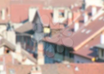 Blurred defocused urban abstract texture background of red tiled roofs of houses in old city in Europe, view of vintage houses with tile roofs in old town, blurred background.