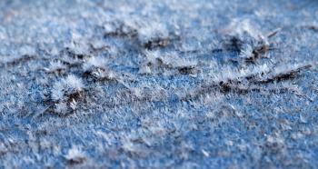 White hoarfrost crystals on flat surface macro view with selective focus, shallow depth of field.