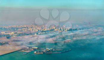 Aerial view of Doha through the morning fog, the capital of Qatar in the Persian Gulf