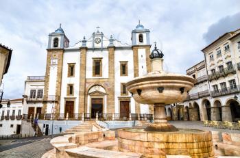 Fountain and Santo Antao Church at Giraldo Square in Evora. UNESCO world heritage in Portugal