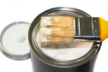 Brush with yellow handle and open paint pot isolated on white background