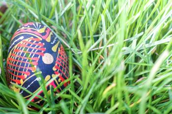 Painted wooden Easter egg in the grass