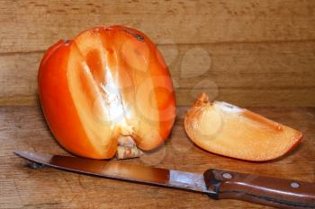 Ripe juicy persimmon on a wooden background