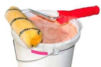Paint roller on a bucket with paint isolated on white background