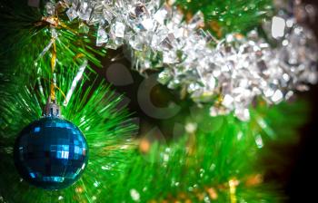 Blurred colorful Christmas background with blue ball and artificial Christmas tree