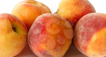 Several ripe peaches on a white background close up