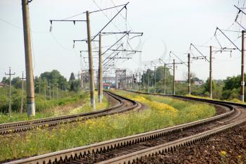Railway track. Perspective view. Summer day. Landscape with green grass and yellow flower