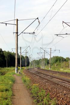 Railway track. Perspective view. Summer day. Landscape with green grass and yellow flower