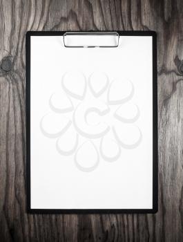 Blank letterhead. Blank sheet of paper in clipboard on dark wooden table background. Blank template for design portfolios. Mock-up for your design.