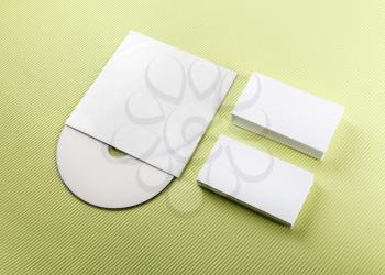 Blank business cards and compact disk on a green background. Template for ID