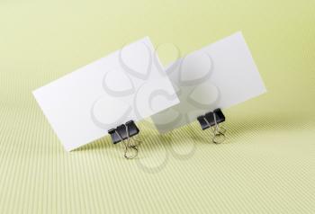 Two blank business card with soft shadows on green background.