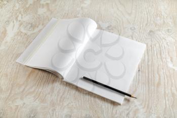 Blank opened diary with a pencil and eraser on light wooden background with soft shadows. Template for design presentations and portfolios.