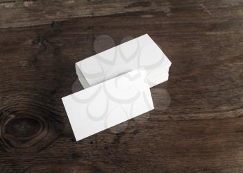 Blank business cards on dark brown wooden background. Template for design presentations and portfolios. Mock-up for branding identity. 